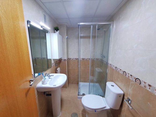 Baño del Bajo con lavabo, retrete y mampara