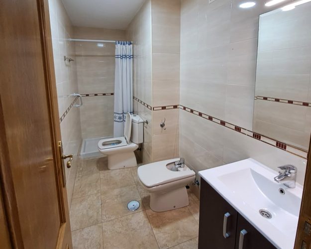 Cuarto de baño con un bidet, una ducha, un retrete, un lavabo y un espejo