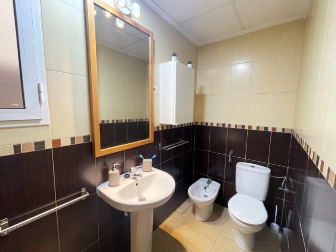 Baño equipado con un espejo, un lavabo, un bidet, un retrete y una ducha