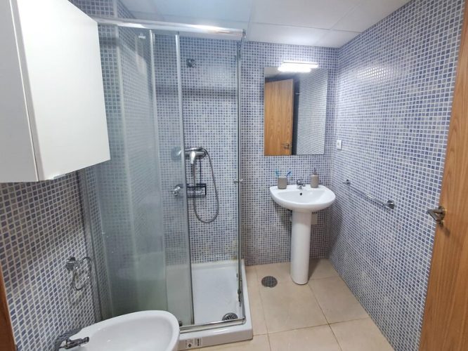 Cuarto de baño con lavabo, bidet, armarito, mampara de ducha, retrete y espejo