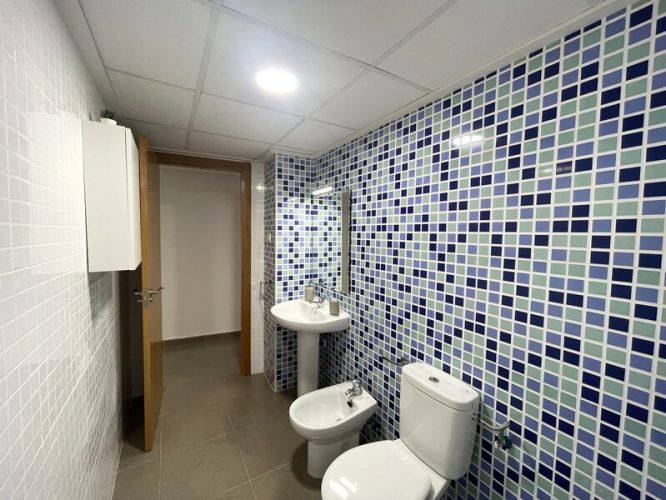 baño equipado con un armarito, un lavabo con espejo, un bidet y un retrete