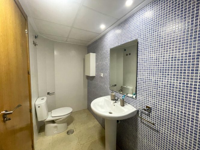 Baño secundario equipado con un lavabo, un espejo y un retrete